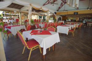 a restaurant with white tables and red chairs at AUX ROCHES ROUGES in Mahajanga