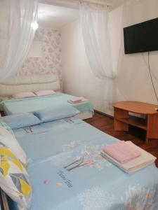 a room with two beds and a flat screen tv at В сердце города! Дерибасовская/Соборная площадь. in Odesa