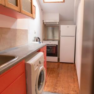 eine Küche mit einem weißen Kühlschrank und einer Waschmaschine in der Unterkunft Nasos Corfu Town Apartment in Korfu-Stadt