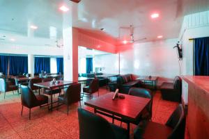 a restaurant with tables and chairs in a room at Hotel Natraj in Bilāspur