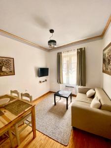 ein Wohnzimmer mit einem Sofa und einem Tisch in der Unterkunft Nasos Corfu Town Apartment in Korfu-Stadt