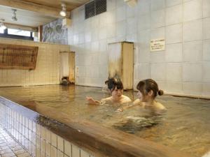 two girls bathing in a hot tub at Aishinkan in Morioka
