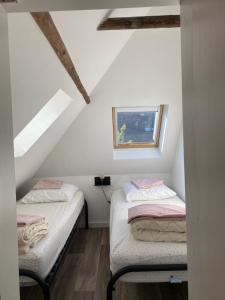 2 camas en un ático con ventana en Wierums Huske aan de Waddenzee Unesco Werelderfgoed, en Wierum
