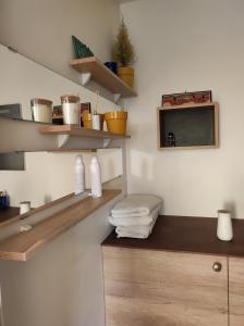 baño con estanterías de madera y lavamanos con toallas en Logement entier+ jardin privé et parking 2places, en Rouen