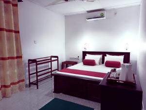 ein Schlafzimmer mit einem Bett und einer Kommode in einem Zimmer in der Unterkunft Sath Rest in Habarana