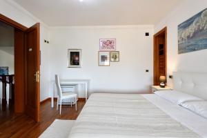 een witte slaapkamer met een bed en een tafel bij Arbatax Sa Omu Bianca in Tortolì