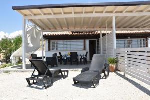 eine Terrasse mit Stühlen und einem Tisch unter einer Pergola in der Unterkunft Casa vacanze Abbacari in Realmonte