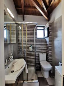 ein Badezimmer mit einem Waschbecken, einem WC und einer Badewanne in der Unterkunft LaZaRTe in Mytilini