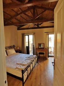 een slaapkamer met een bed en een houten vloer bij LaZaRTe in Mytilini