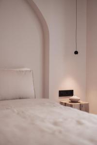 a white bedroom with a bed and a table at Om Living Afitos in Afitos