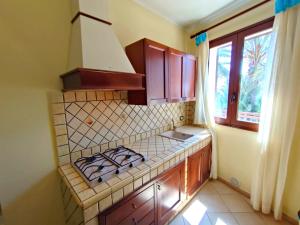 a kitchen with a stove top and a window at Puesta De Sol Residence in Lampedusa