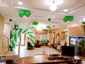 une chambre avec des ballons verts et blancs au plafond dans l'établissement Hotel SR Lounge Multan, à Multan