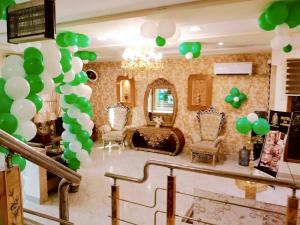 - un bouquet de ballons verts et blancs dans une pièce dans l'établissement Hotel SR Lounge Multan, à Multan