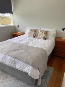 a bedroom with a bed with pillows and a window at Large Kingston Beach Home Setup For Comfort in Kingston Beach