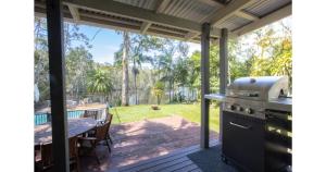 a screened in porch with a grill and a table at The Lake House - Cabarita Beach in Cabarita Beach