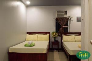 a room with two beds with towels on them at GETZ HOTEL MANILA in Manila