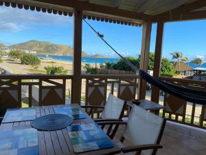 - une terrasse couverte avec un hamac et une vue sur la plage dans l'établissement Lovely one bedroom holiday home by the beach, à La Baie-Orientale
