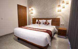 a bedroom with a large white bed and a night stand at The Kd Suites & Coffee Shop in Munggu