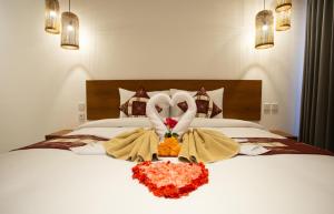 a bed with two swans made out of towels at The Kd Suites & Coffee Shop in Munggu