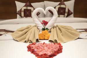 two swans making a heart shape on a bed at The Kd Suites & Coffee Shop in Munggu
