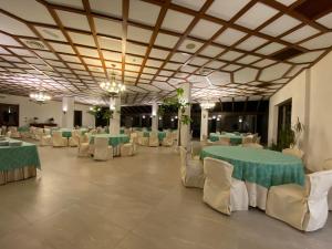 una sala banchetti con tavoli e sedie verdi e bianchi di Hotel Primavera Dell'Etna a Zafferana Etnea