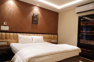 sypialnia z łóżkiem i brązową ścianą w obiekcie L. R RESIDENCY w mieście Kanchipuram