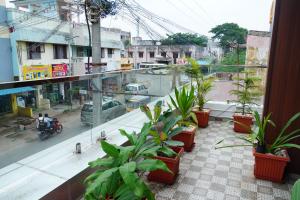 een balkon met potplanten in een stadsstraat bij L. R RESIDENCY in Kanchipuram