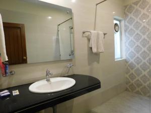 a bathroom with a sink and a mirror at Hotel SR Lounge Multan in Multan