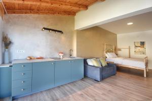 a kitchen with a blue island in a room with a bed at Apartments Forum 2 in Pula