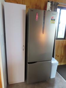 a refrigerator in a kitchen next to a window at Westmere Retreat in Westmere +12 photos