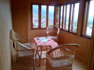 a dining room with a table and chairs and windows at Panorama in Yaremche