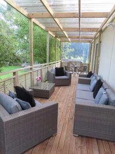 Westmere的住宿－Westmere Retreat，平台上设有带沙发和桌子的庭院