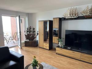 ein Wohnzimmer mit einem großen Flachbild-TV in der Unterkunft Apartment 31 in Wilhelmshaven