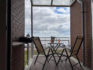 eine Terrasse mit 2 Stühlen und einem Tisch auf dem Balkon in der Unterkunft Apartment 31 in Wilhelmshaven