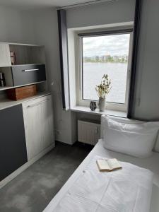 ein Zimmer mit einem Bett und einem Fenster mit einem Buch darauf in der Unterkunft Apartment 31 in Wilhelmshaven