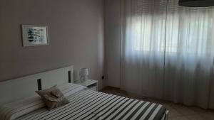 a white bedroom with a bed and a window at Casa Nino in Roseto degli Abruzzi