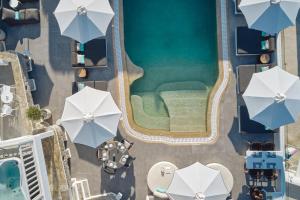 - une vue sur la piscine bordée de parasols dans l'établissement Mykonos Princess Hotel, à Agios Stefanos