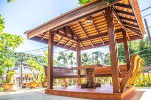 a wooden pavilion with two chairs and a bench at Kata Pool Villa ​No.7 in Kata Beach