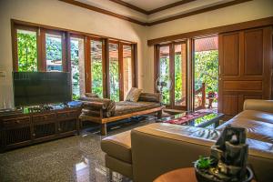 a living room with a couch and a flat screen tv at Kata Pool Villa ​No.7 in Kata Beach