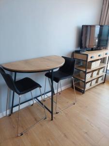 a table and two chairs in a room with a tv at Studio Cabine Sète Corniche Vue Mer in Sète