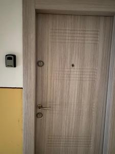 a wooden door with a clock on a wall at Grove Apartment in Buzău