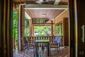 a dining room with a table and chairs on a patio at Kata Pool Villa ​No.7 in Kata Beach