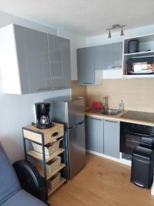 une cuisine avec un réfrigérateur en acier inoxydable et un évier dans l'établissement Studio Cabine Sète Corniche Vue Mer, à Sète