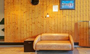 una silla marrón en una habitación con una pared de madera en Itsy By Treebo - Friends, en Haldwāni