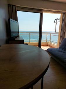 a living room with a table and a view of the ocean at Studio Cabine Sète Corniche Vue Mer in Sète