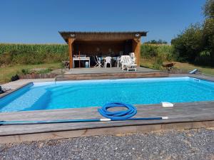 a swimming pool with a table and a gazebo at Gîte Izabeau in Pouillon