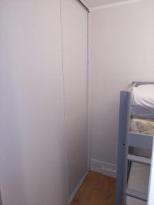 une petite chambre avec un lit et un placard dans l'établissement Studio Cabine Sète Corniche Vue Mer, à Sète