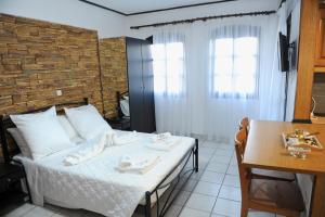 a bedroom with a bed and a table and a window at Karlovasi Studios in Karlovasi