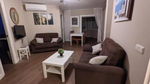 sala de estar con sofá y mesa en Precioso apartamento junto a playa y con piscina., en Málaga