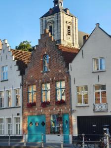 un edificio de ladrillo con una torre encima en B&B Huyze Walburga, en Brujas